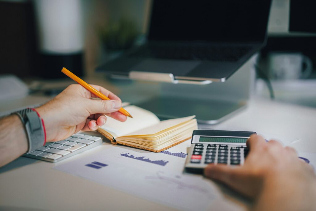 Person reviewing financial documents with a calculator, representing planning for Uruguay foreign income tax changes.